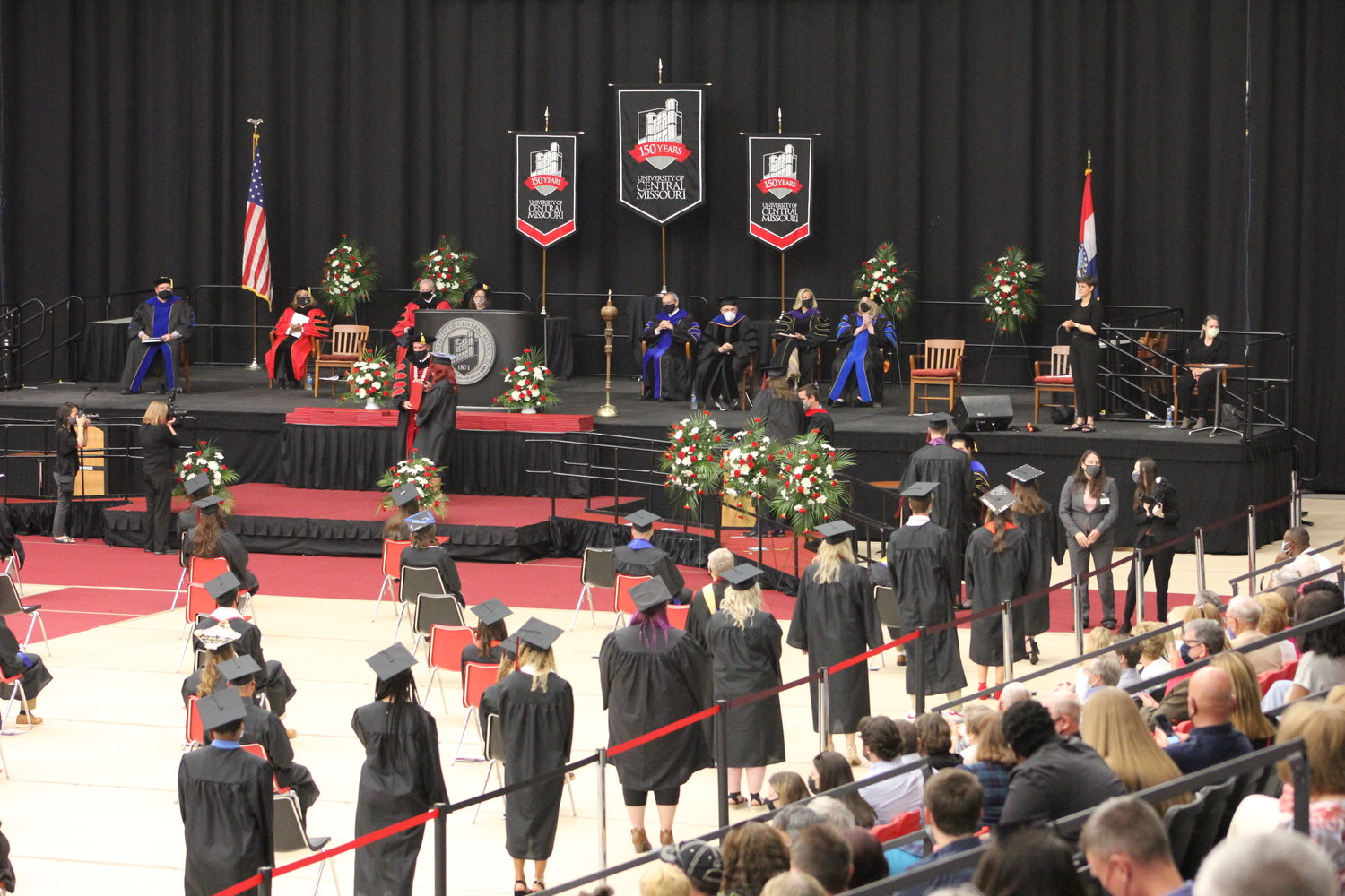 Graduates line up to have their names read before being presented with a diploma cover by President Roger Best.